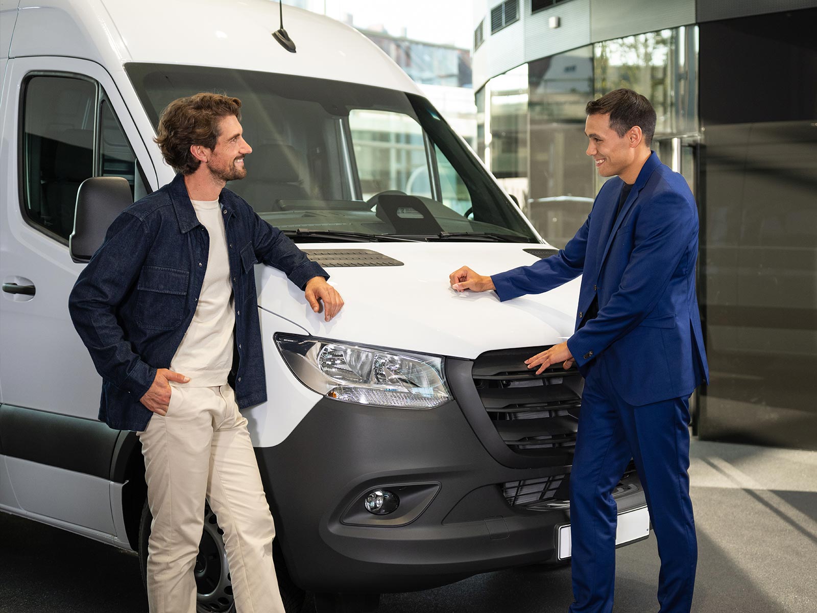 Oferta finansowania dla przedsiębiorstw | Vito Tourer | Samochody dostawcze Mercedes-Benz Dwóch mężczyzn rozmawia stojąc obok białego Sprintera Mercedes-Benz.