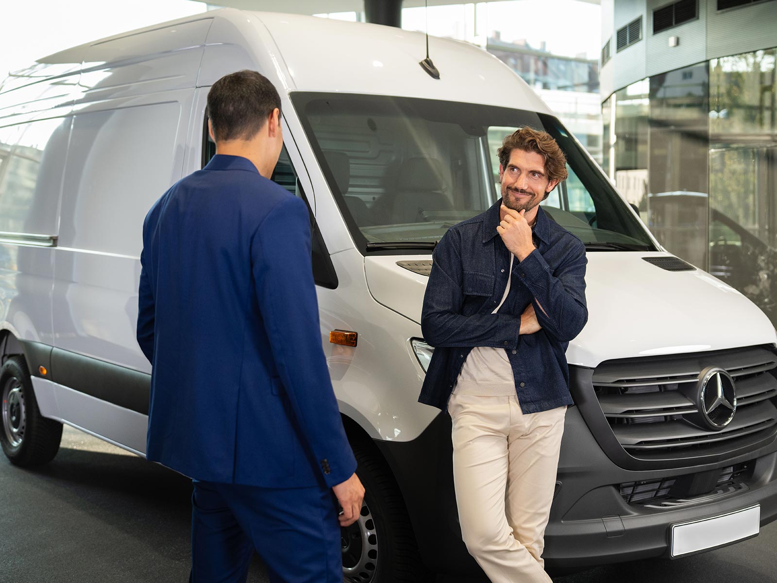 Ubezpieczenie samochodu dostawczego | eSprinter Podwozie do zabudowy | Mercedes-Benz Dwóch mężczyzn rozmawia stojąc obok białego Sprintera Mercedes-Benz.