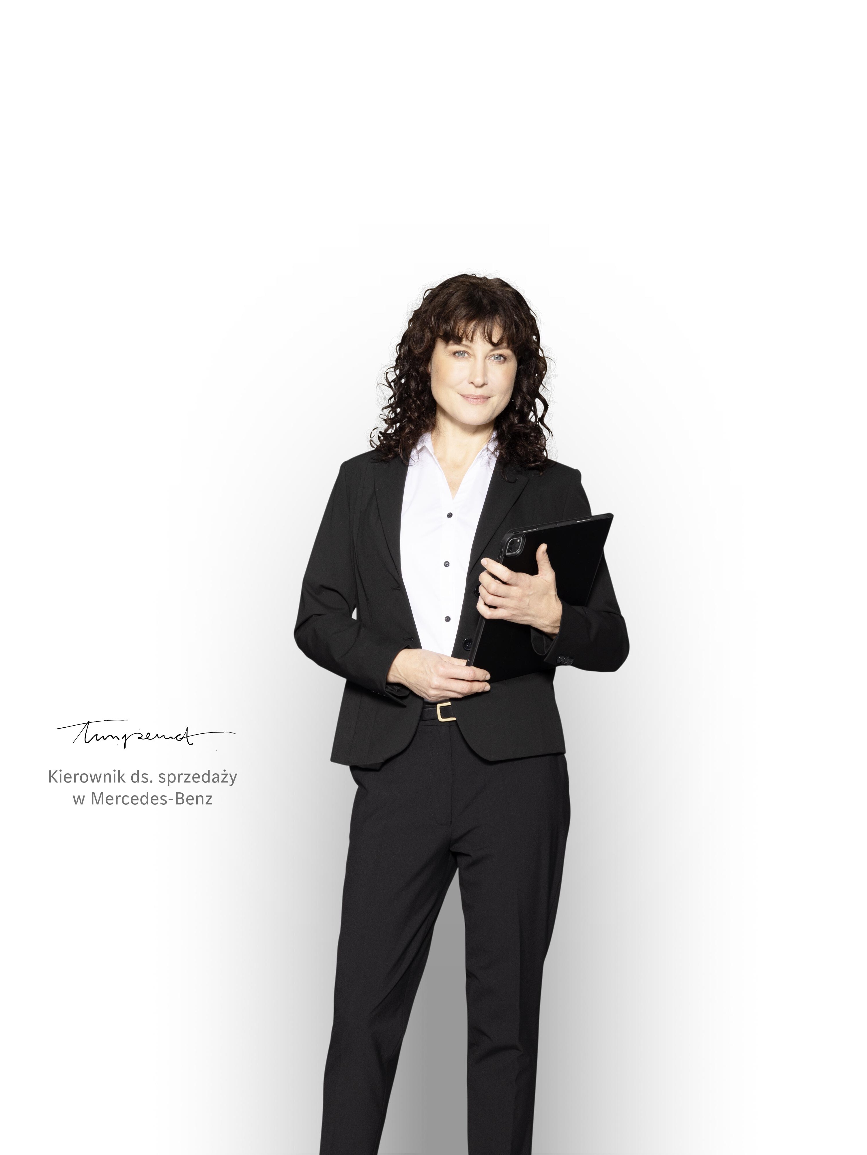 Kierownik ds. sprzedaży Mercedes-Benz z tabletem, gotowy do udzielania informacji na temat pakietów serwisowych.