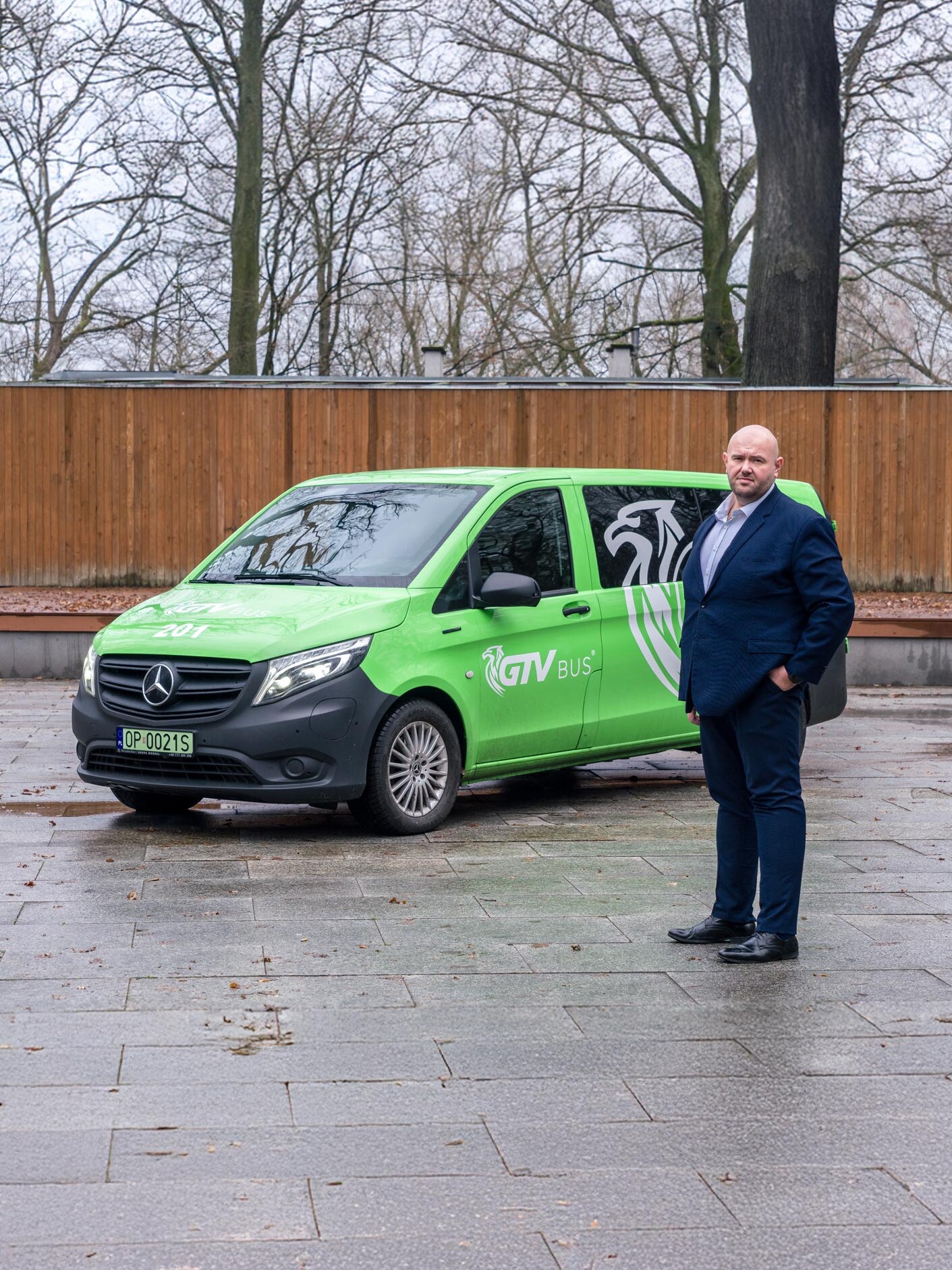 Tomasz Oleśków, dyrektor operacyjny GTV Bus, na tle zielonego Mercedesa eVito Tourer