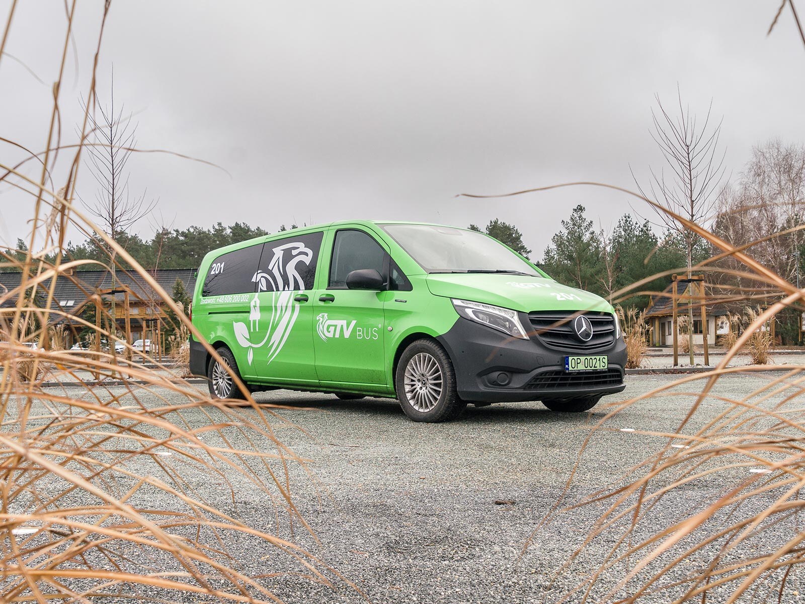 Zielony Mercedes eVito Tourer firmy GTV Bus stoi na parkingu.