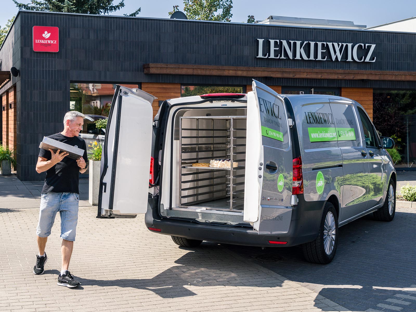 Cukiernia Lenkiewicz: dolce eVito Mężczyzna podchodzi do Mercedesa eVito zaparkowanego przed cukiernią.