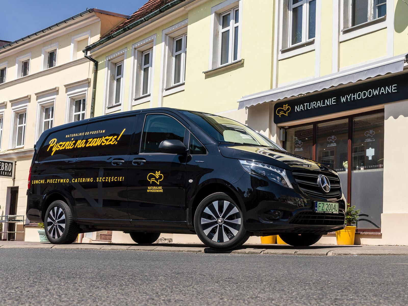 Czarny Mercedes eVito zaparkowany przed lokalem firmy Naturalnie Wyhodowane.
