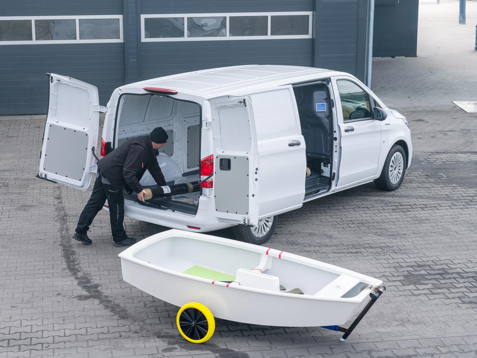 eVito w firmie Optimast Pracownik firmy Optimast wkłada osprzęt żeglarski do Mercedes-Benz eVito Furgon.