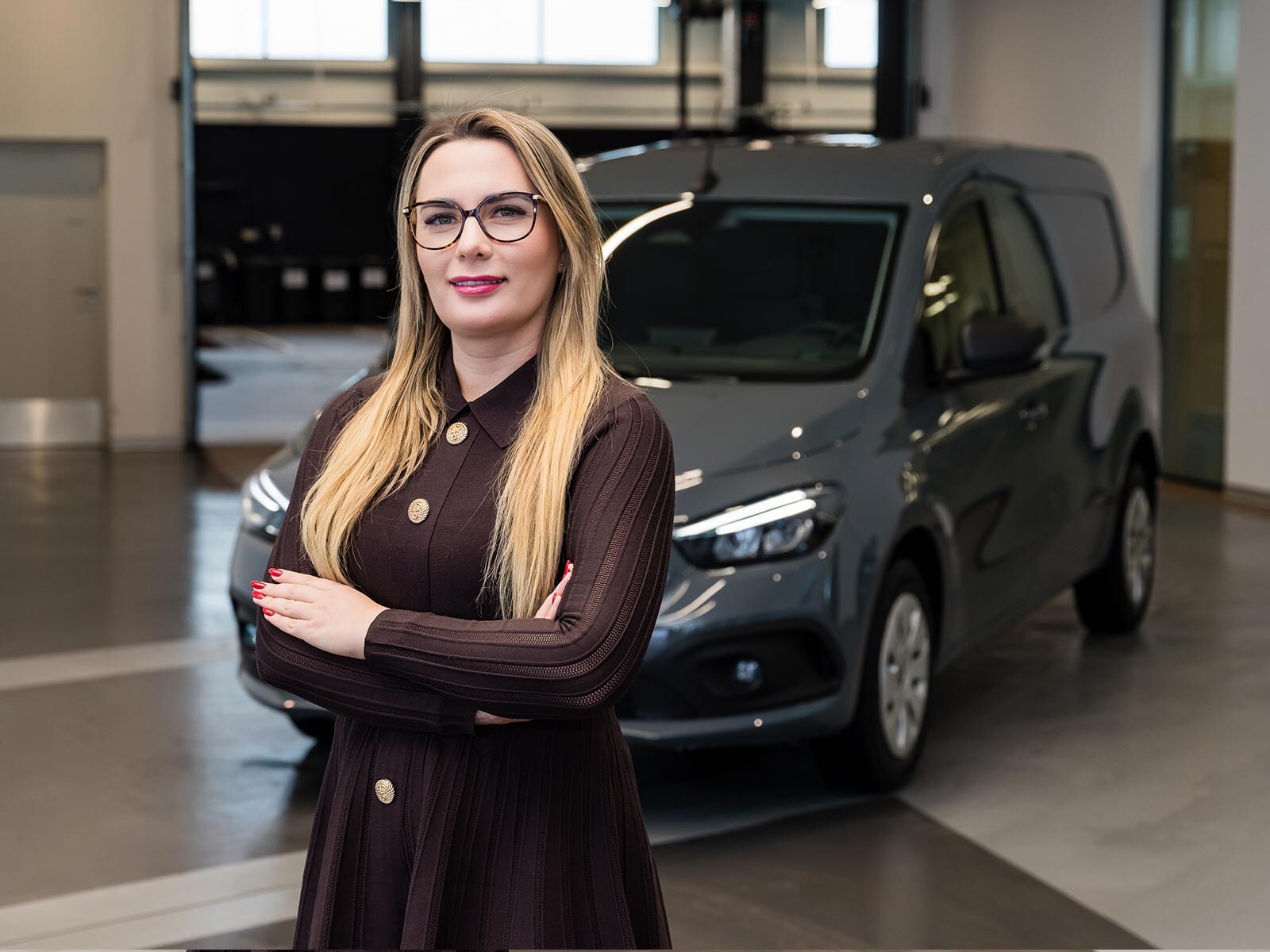 Ewelina Giłudź-Matuszak stoi przed szarym Mercedesem eCitan.