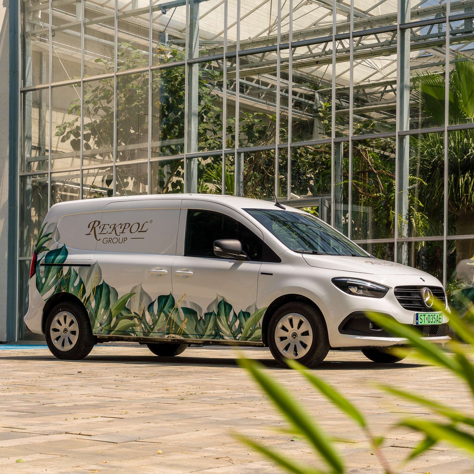 eCitany w Rekpol Group Biały eCitan Furgon przed szkarnią.