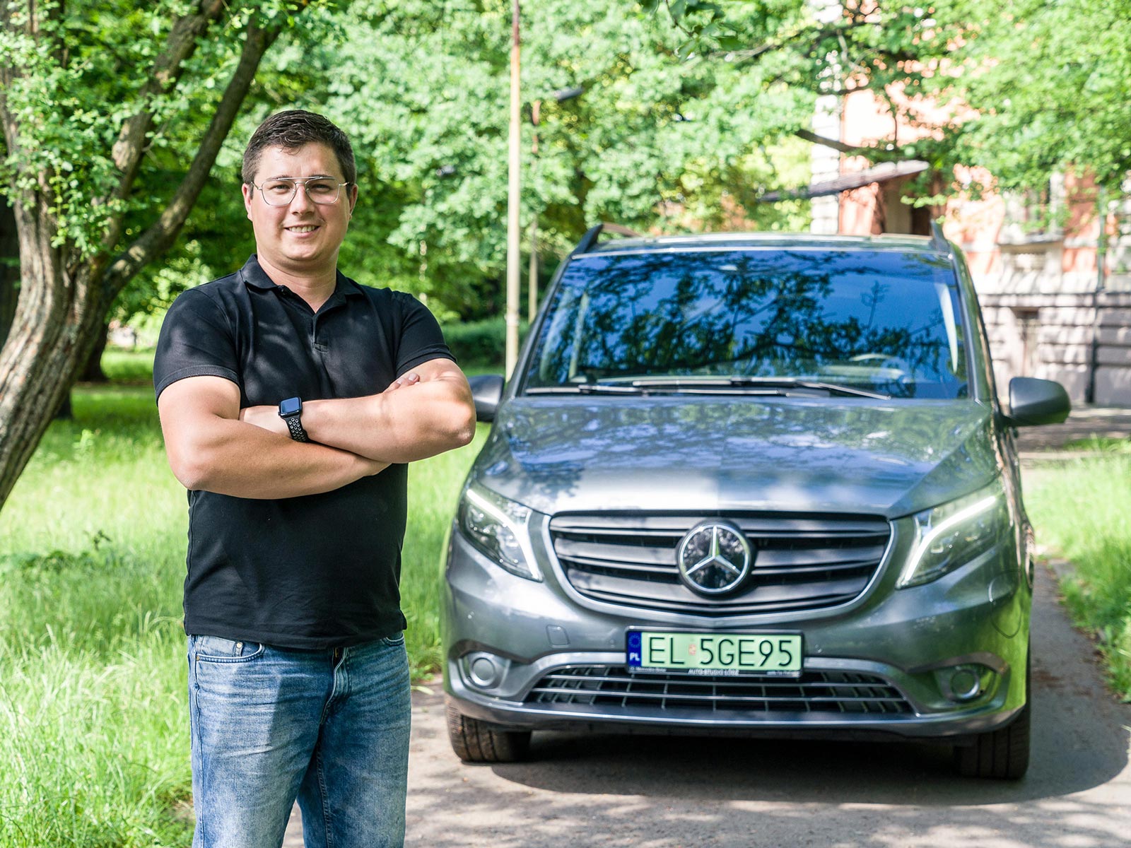eVito: dobry start w elektromobilność Mężczyzna stoi obok szarego Mercedesa eVito na tle zieleni.